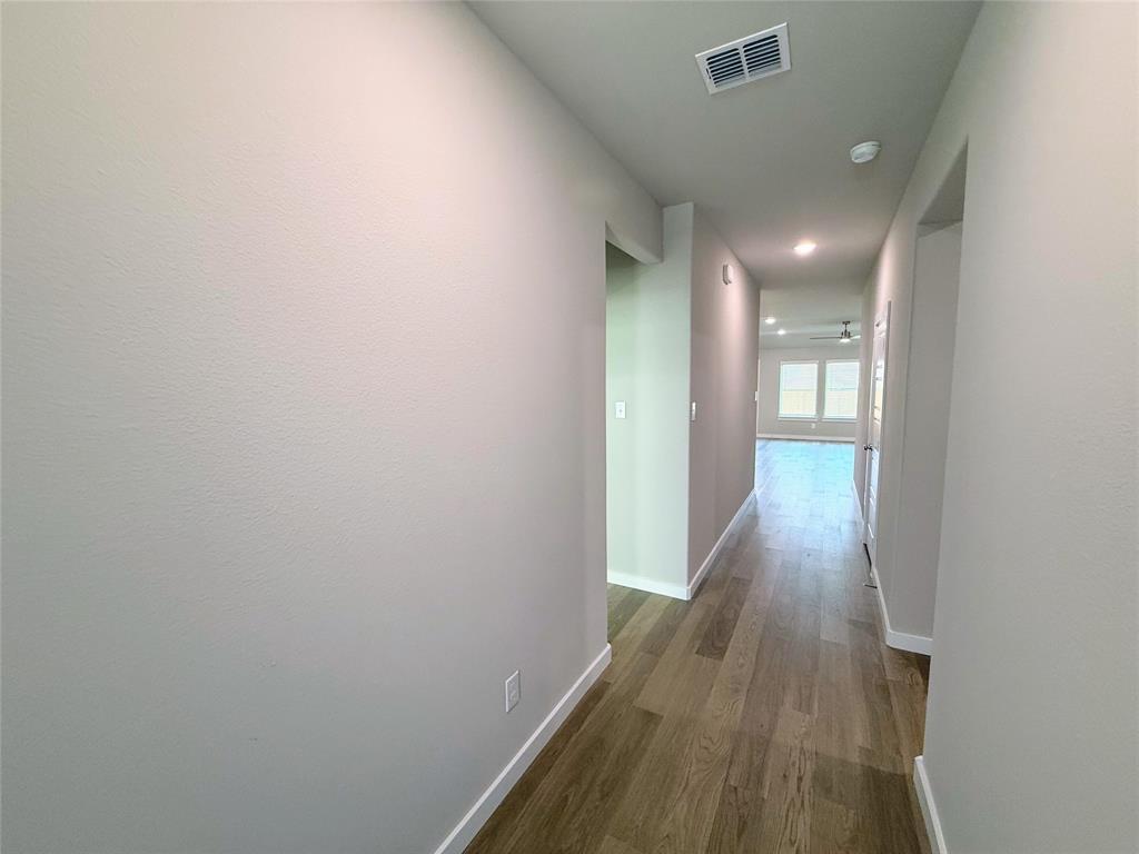 1909 Sandpiper Way Princeton, TX 75407 - Photo 4 of 35 Corridor with baseboards and dark wood finished floors