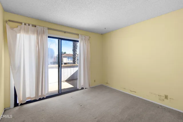 a view of an empty room and kitchen