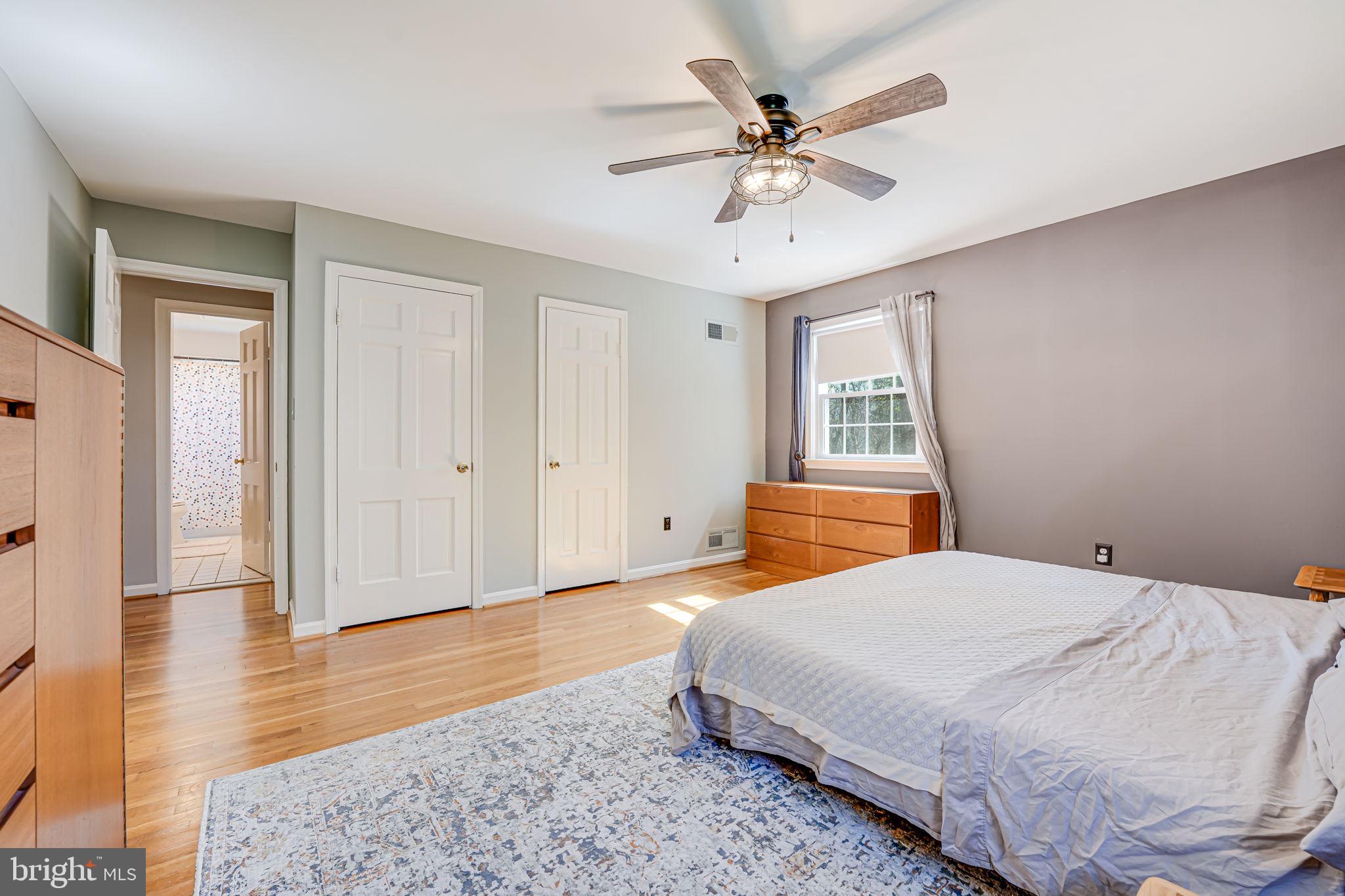 12132 Stirrup Road Reston, VA 20191 - Photo 24 of 67 a bedroom with a large bed a chandelier and closet