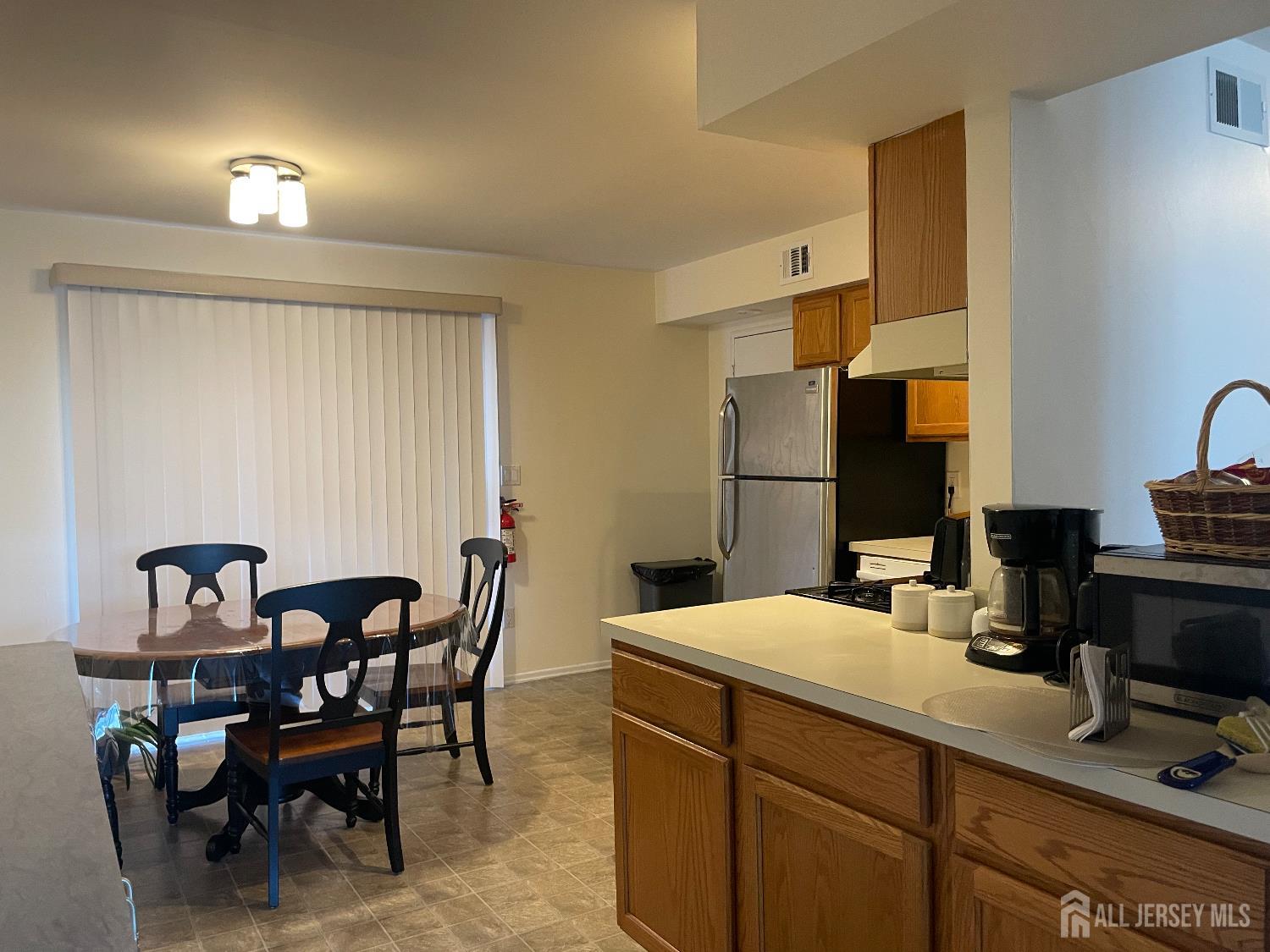 182 Evergreen Road, Unit 3B Edison, NJ 08837 - Photo 3 of 9 a room with a table chairs and a refrigerator