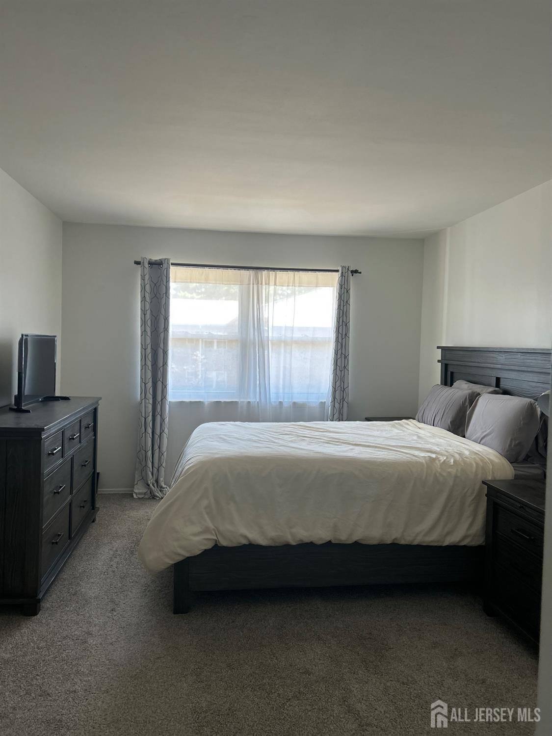 182 Evergreen Road, Unit 3B Edison, NJ 08837 - Photo 9 of 9 a spacious bedroom with a bed and wooden floor