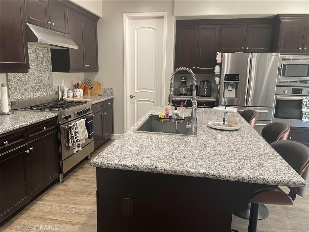 1563 Silver Shadow Drive Thousand Oaks, CA 91320 - Photo 15 of 24 a kitchen with granite countertop kitchen island stainless steel appliances a sink stove and refrigerator