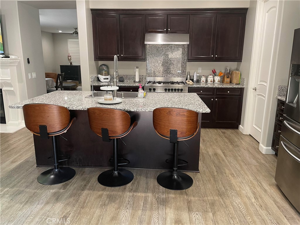 1563 Silver Shadow Drive Thousand Oaks, CA 91320 - Photo 7 of 24 a kitchen with stainless steel appliances granite countertop a sink a stove and chairs with wooden floor