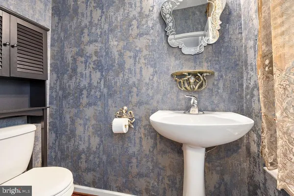 a bathroom with a sink a toilet and mirror