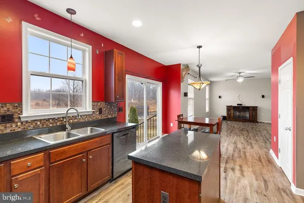 a kitchen with kitchen island granite countertop a sink stove and cabinets