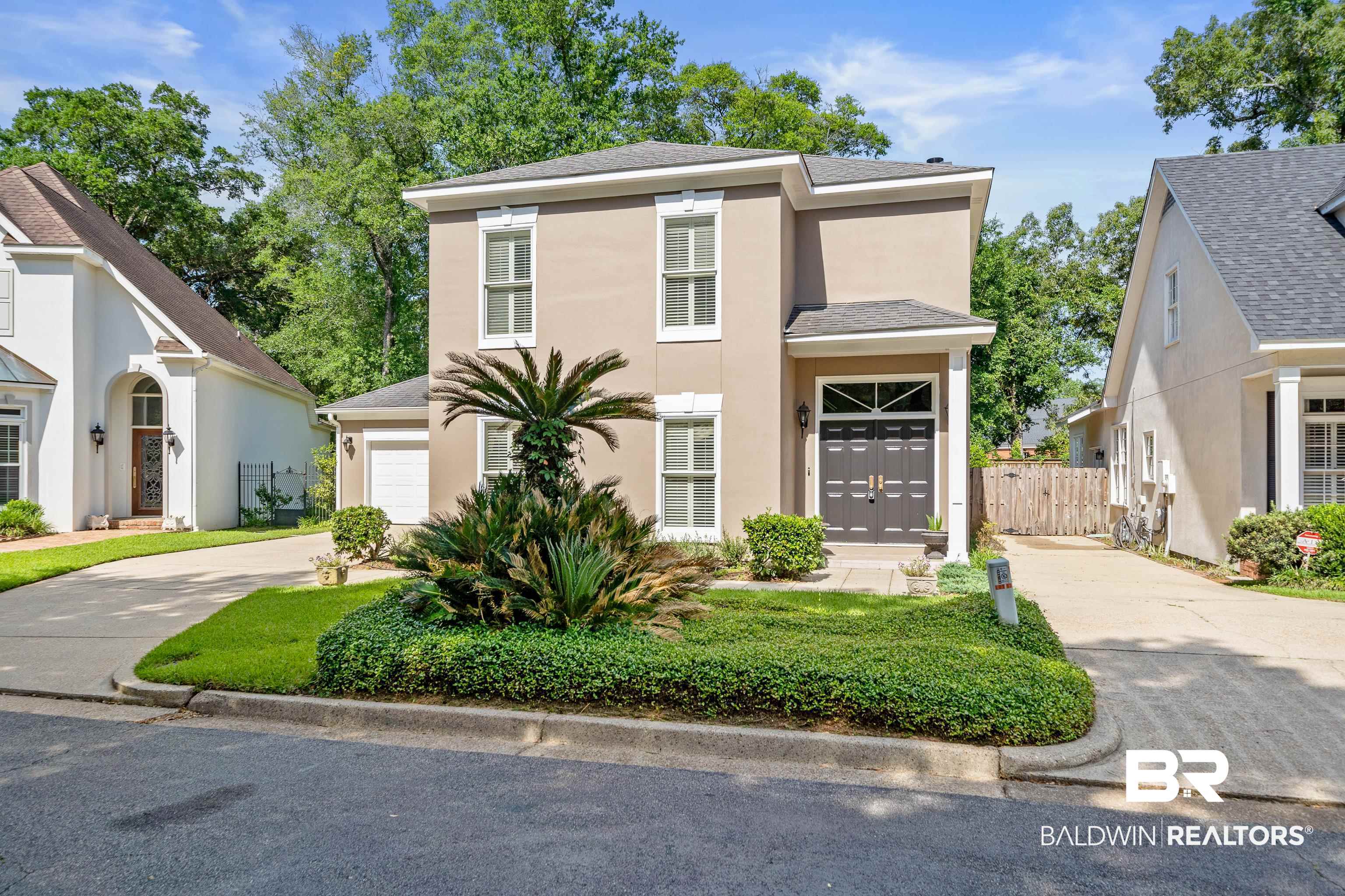 4272 Bit And Spur Road, Unit 12 Mobile, AL 36608 - Photo 1 of 34 View of front of property featuring concrete driveway, stucco siding, fence, an attached garage, and roof with shingles