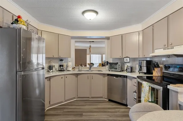 a kitchen with granite countertop a sink stainless steel appliances and cabinets