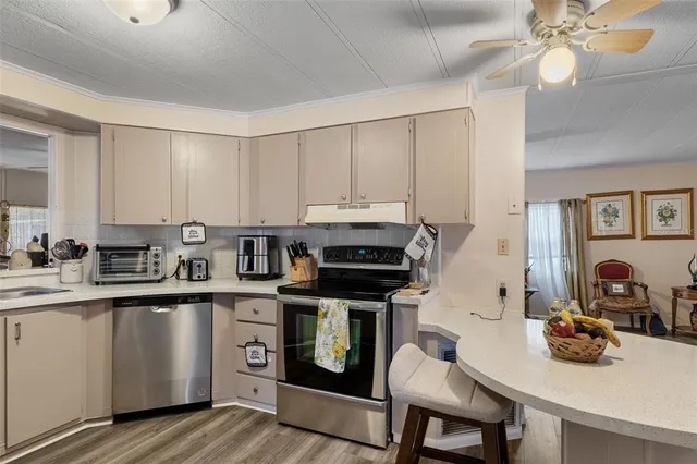 a kitchen with stainless steel appliances a stove a sink cabinets and a dining table