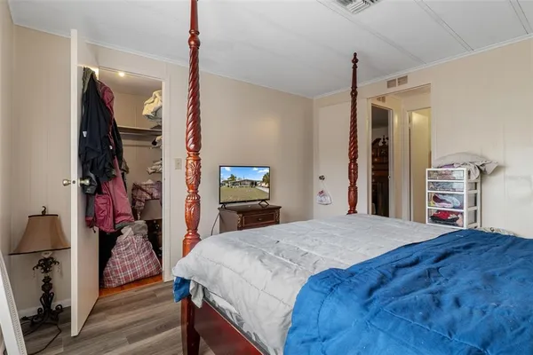 a bedroom with a bed and a flat tv screen on a dresser