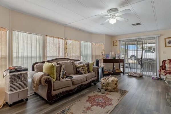 a living room with furniture and three large window