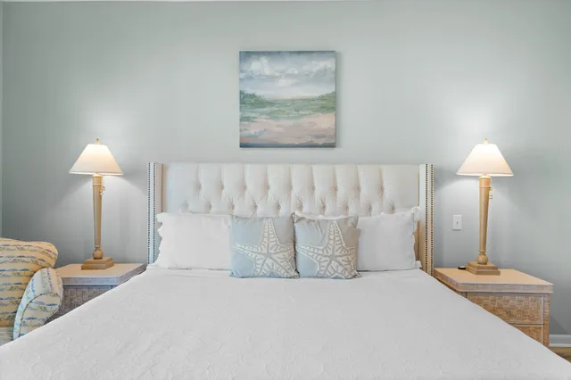 a bedroom with a large bed and a chandelier