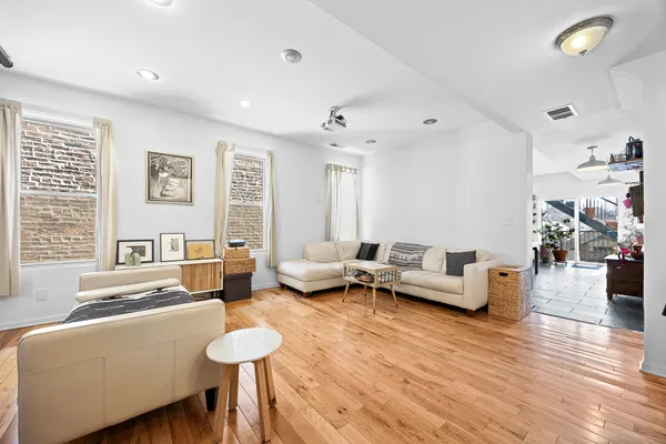 a open kitchen with stainless steel appliances kitchen island granite countertop a stove a sink a dining table and chairs with wooden floor