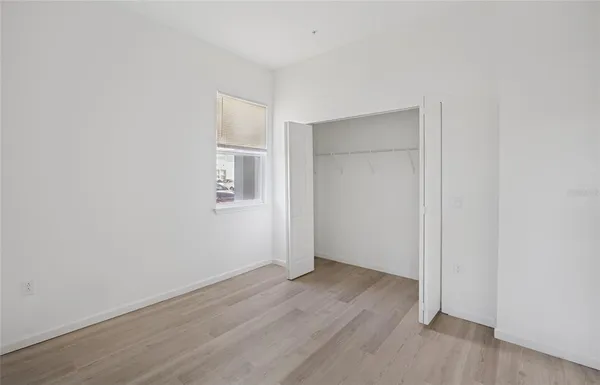an empty room with wooden floor and closet