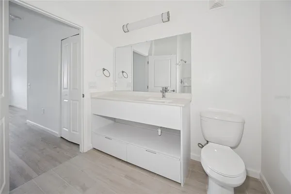 a bathroom with a toilet sink vanity and mirror