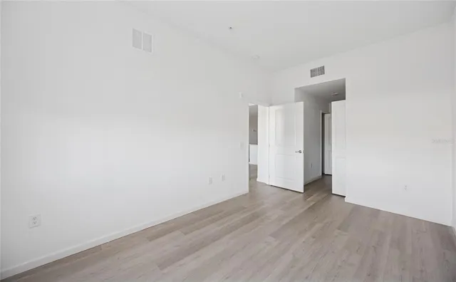 a view of an empty room with wooden floor