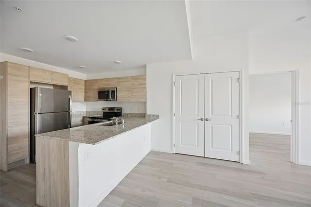 a kitchen with stainless steel appliances a refrigerator and a stove top oven