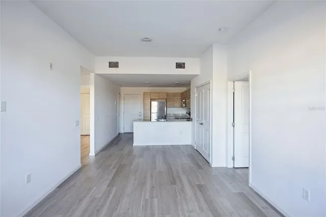 a view of a hallway with wooden floor and a bathroom
