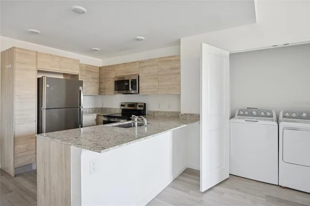 a kitchen with a refrigerator a microwave a sink and a stove