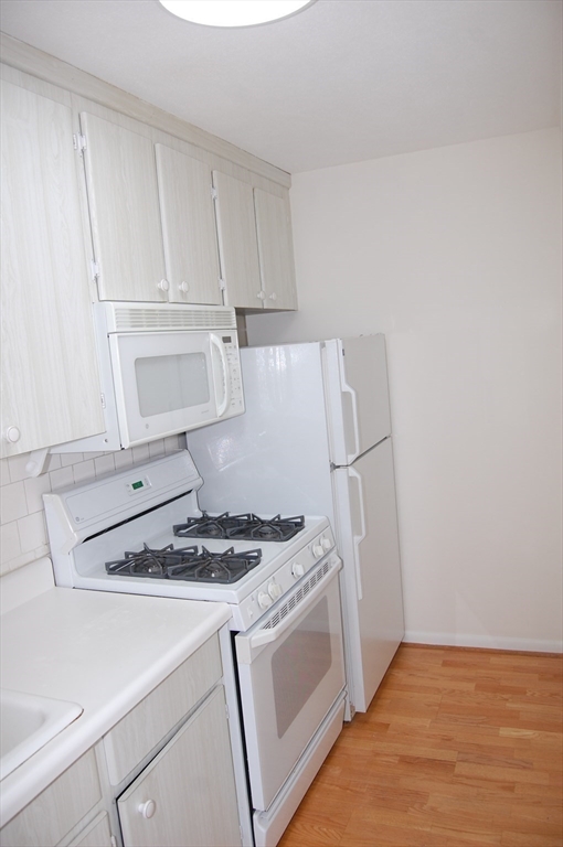 48 Will Drive, Unit 72 Canton, MA 02021 - Photo 3 of 19 a kitchen with white cabinets and a stove