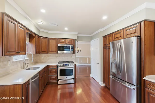 a kitchen with stainless steel appliances granite countertop a refrigerator stove and sink