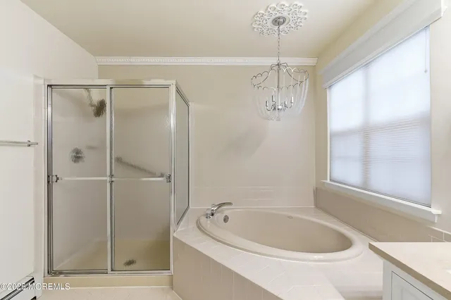 a bathroom with a tub a sink and window