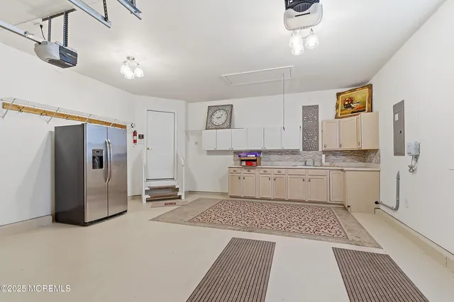 a kitchen with white cabinets and refrigerator