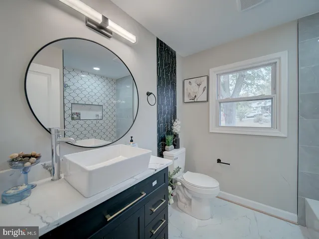 a bathroom with a toilet a sink and a mirror