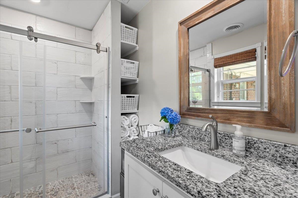 4491 Garnett Road Memphis, TN 38117 - Photo 18 of 32 Bathroom featuring a glass-enclosed shower with subway tile surround and pebble-style floor
