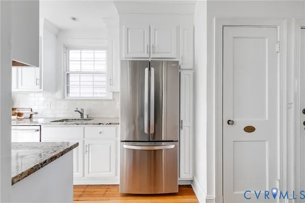 a kitchen with granite countertop a refrigerator and a sink