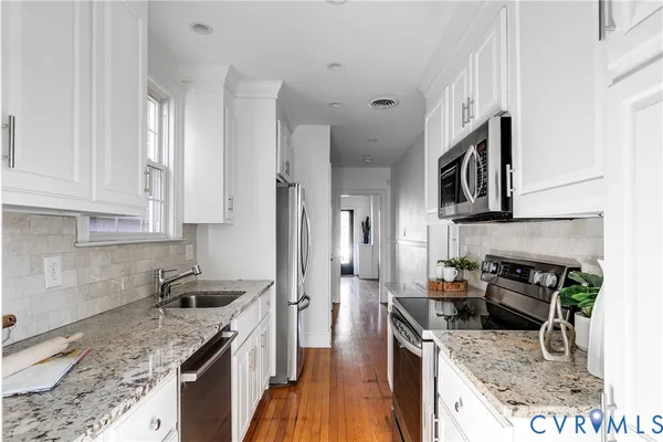 a kitchen with stainless steel appliances granite countertop a sink stove and refrigerator