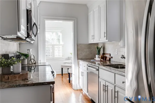 a kitchen with stainless steel appliances granite countertop a sink stove and cabinets