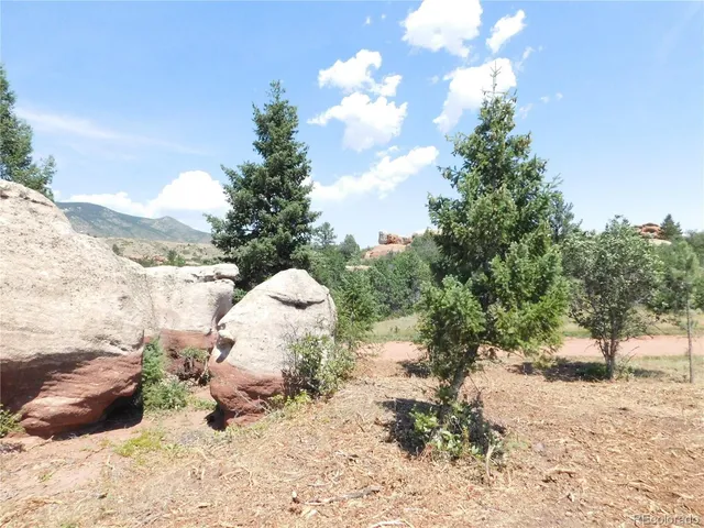 a view of a dirt road with a building in the background