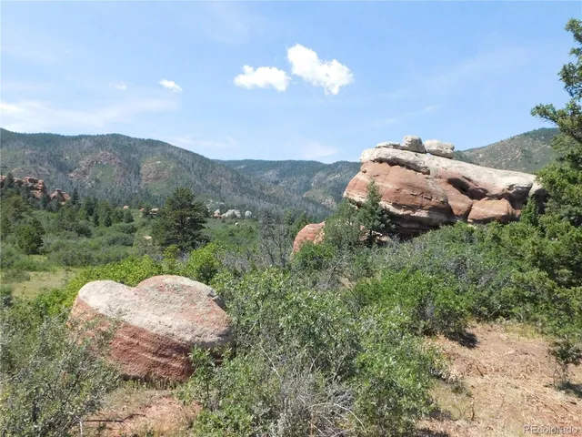a view of a green field with mountains in the background