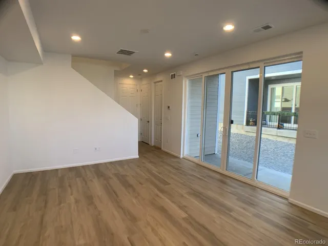 an empty room with wooden floor and sliding door
