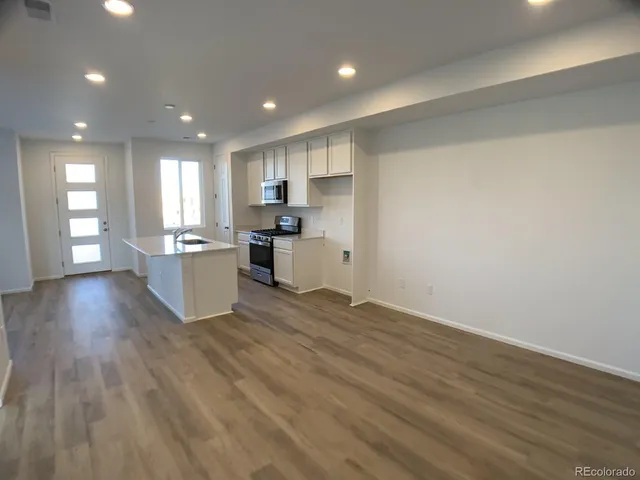 a kitchen with a sink a counter top space stainless steel appliances and cabinets