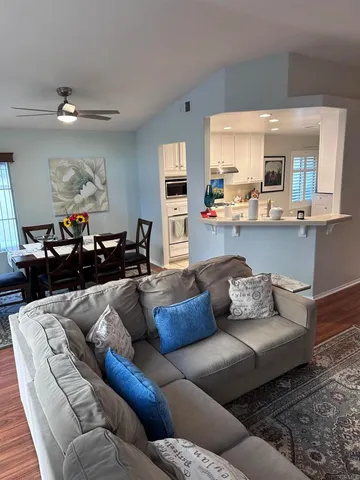 a living room with furniture and a wooden floor