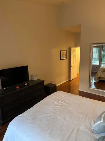 a bedroom with a bed and a flat screen tv
