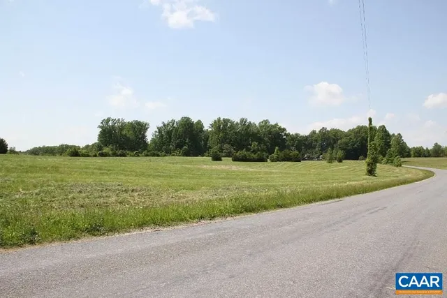 a view of a green field with wooden fence