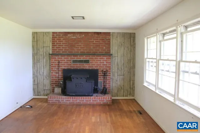 a view of an empty room with a fireplace and a window