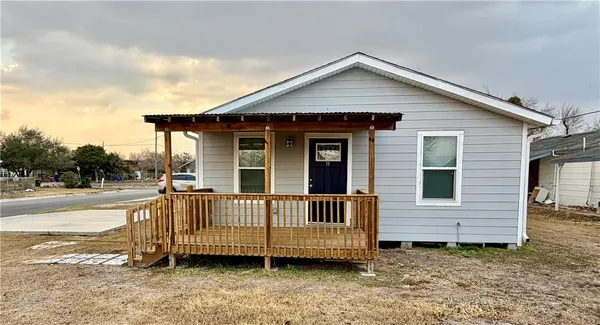 a view of a house with a yard and deck