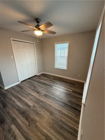 a view of a livingroom with wooden floor and a ceiling fan