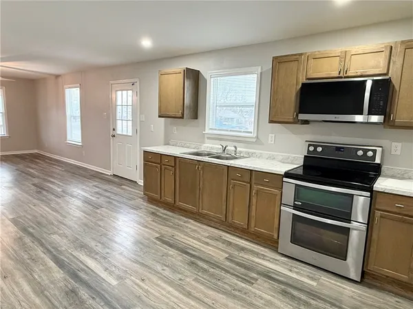 a kitchen with stainless steel appliances a stove microwave and sink
