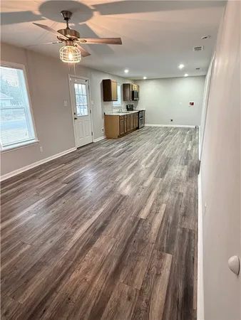 a view of a livingroom with a chandelier fan and wooden floor