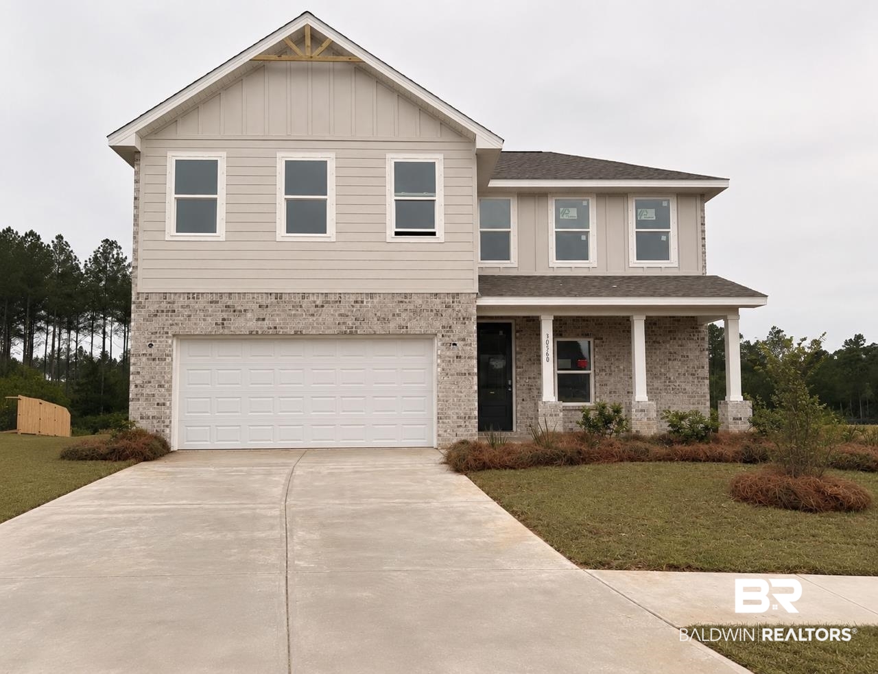 30560 Asheville Road Daphne, AL 36527 - Photo 1 of 26 Contemporary two-story residence featuring a combination of brick and siding, a two-car garage, and a covered front porch with columns