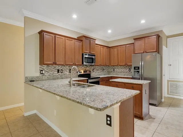 a kitchen with stainless steel appliances granite countertop a sink stove and refrigerator