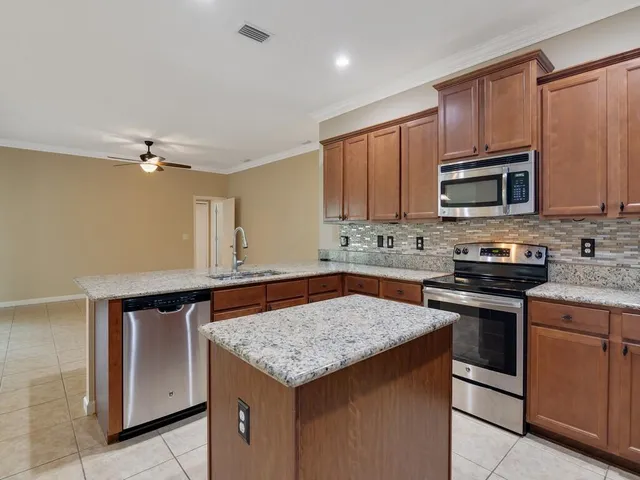 a kitchen with granite countertop a stove cabinets and microwave