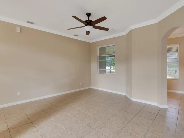 an empty room with windows and ceiling fan