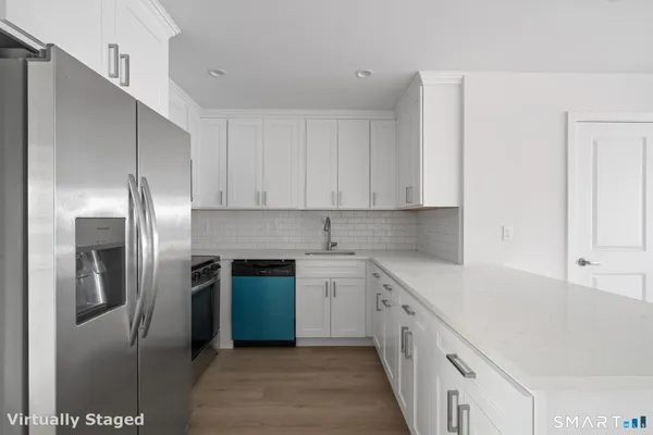 a kitchen with stainless steel appliances granite countertop a refrigerator and a sink