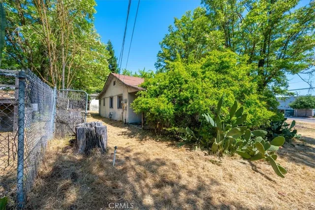 a backyard of a house with table and chairs under an umbrella