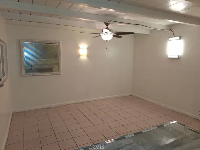 en empty room with windows and chandelier fan